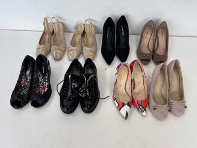 plusieurs paires de chaussures de femmes sont alignées sur une surface blanche