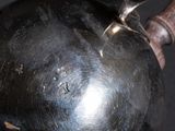 a metal object with a wooden handle on a black surface