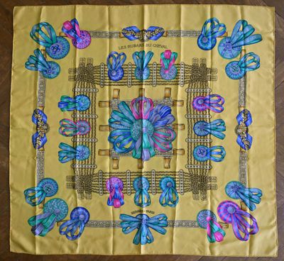 une écharpe jaune ornée de papillons bleus et roses, posée sur un parquet