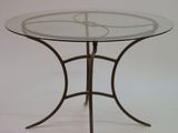 une table en verre avec une base en métal et un plateau en verre