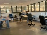 une salle où se trouvent de nombreux bureaux et chaises