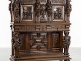 une vieille armoire en bois ornée de sculptures sur la façade