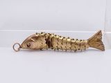 gold plated fish keychain with gold spikes on it ' s back