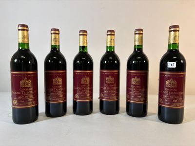 six bouteilles de vin sont alignées sur une table