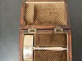 a small wooden box with a razor in it on a table