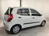 the small white car is parked in a large room