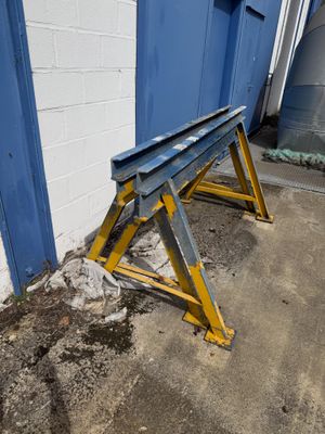 un banc en métal posé devant une porte bleue