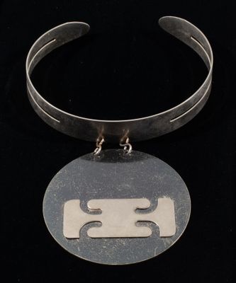an image of a necklace with a face on it on a black background