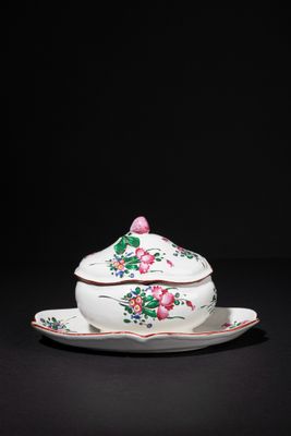 a white and pink porcelain bowl and saucer on a black surface