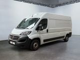 La camionnette blanche est garée dans la grande salle du bâtiment.