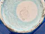 a close up of a blue vase on a table