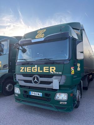 two green trucks parked next to each other in a parking lot
