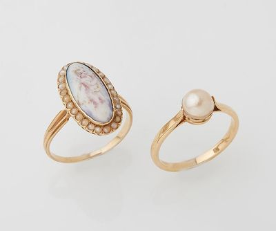 a pair of gold rings with a pearl and mother ' s day stone