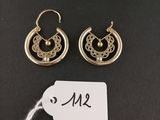 a pair of earrings with a price tag on a black background