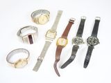 de nombreuses montres et bracelets de toutes sortes disposés sur une surface blanche