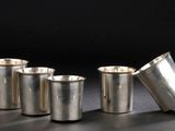 quatre tasses en argent posées les unes à côté des autres sur une table