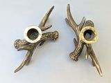 two metal candlesticks that are sitting next to each other