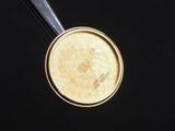 a close up view of a gold coin with a black background