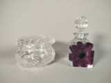 a small glass jar with a purple flower inside of it