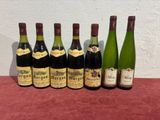 six bottles of wine are lined up on a table