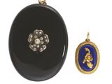 une image représentant une broche ovale noire ornée d'un fermoir en or et d'une perle