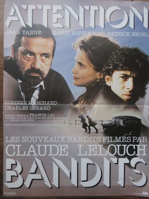 L'affiche du film « Attention » est posée sur une table en bois.