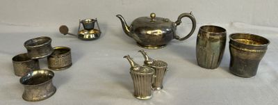 des théières, des tasses et des vases en métal argenté posés sur une table