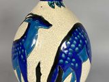 un vase bleu et blanc orné d'un motif représentant un cerf
