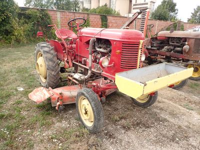 un tracteur rouge assis dans l'herbe