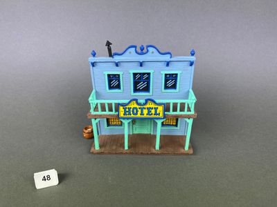 un gros plan d'un bâtiment miniature sur lequel est accrochée une pancarte