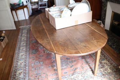 une table en bois sur laquelle est posée une boîte contenant de la vaisselle