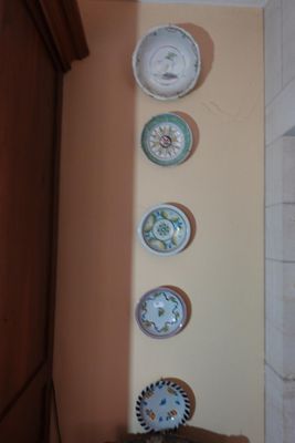 de nombreuses assiettes accrochées au mur au-dessus d'une chaise
