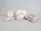 four pieces of porcelain furniture including a chair, bowl, and tray