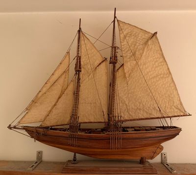 a wooden model of a sailboat on a shelf