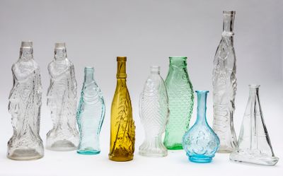 many different colored glass bottles lined up on a white surface