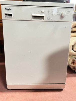 an image of a white dishwasher sitting on top of a pink floor