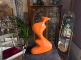 an orange sculpture sitting on top of a black table