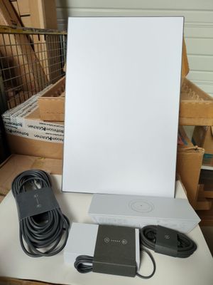 une photo représentant une boîte blanche avec un cordon d'alimentation et un chargeur posés sur une table