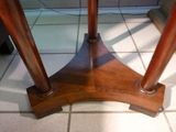 a wooden table with a glass top on a tiled floor
