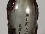 a small glass bottle with writing on it sitting on a table