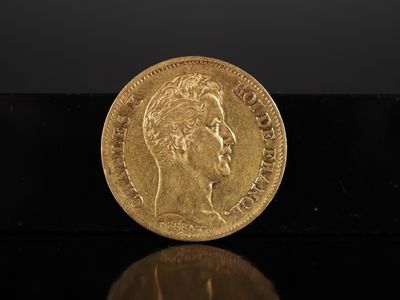 gros plan d'une pièce d'or sur une surface noire