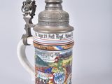a beer mug with a statue on top of it