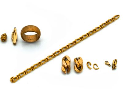 un bracelet en or, une bague et d'autres bijoux posés sur un fond blanc