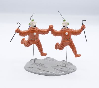 deux figurines de clowns sont posées sur un rocher