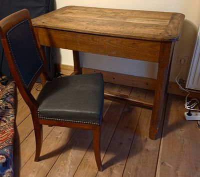 une petite table en bois avec une chaise noire à côté
