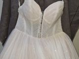 wedding dress hanging on a hanger in front of a coat