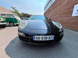 a black porsche parked in a parking lot next to a building