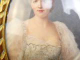 une photo d'une femme en robe blanche dans un cadre doré