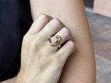 a woman wearing a ring that has a diamond on it