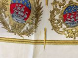 a white table cloth with a gold border and a picture of a ship on it